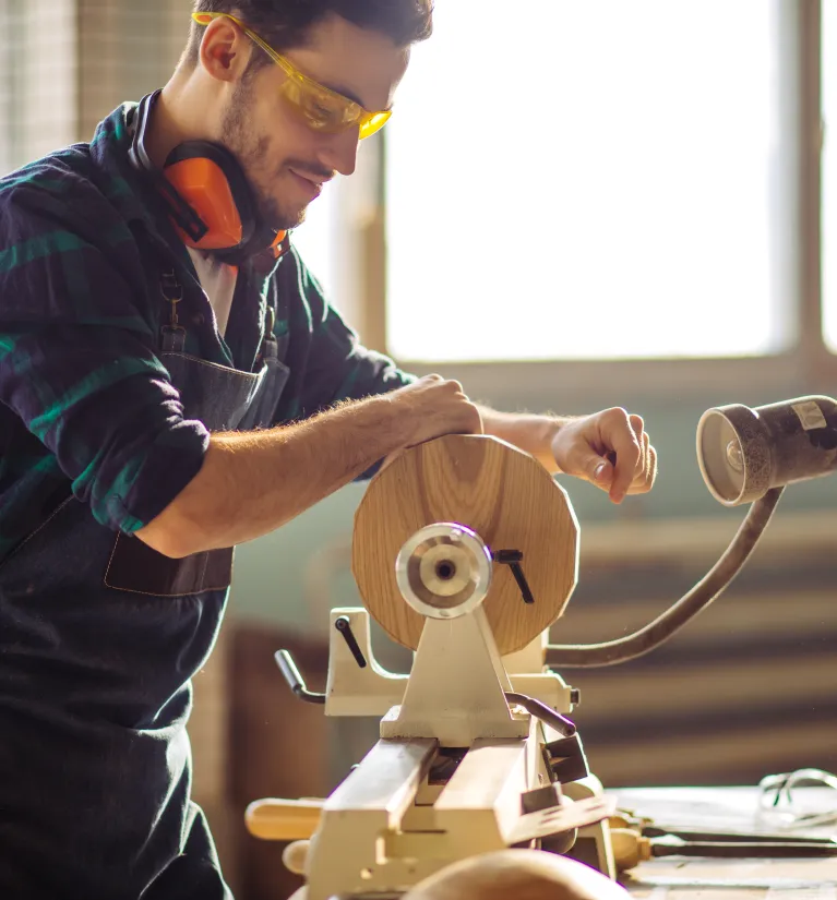 Energia+ stała cena. Stolarz pracujący w swoim warsztacie